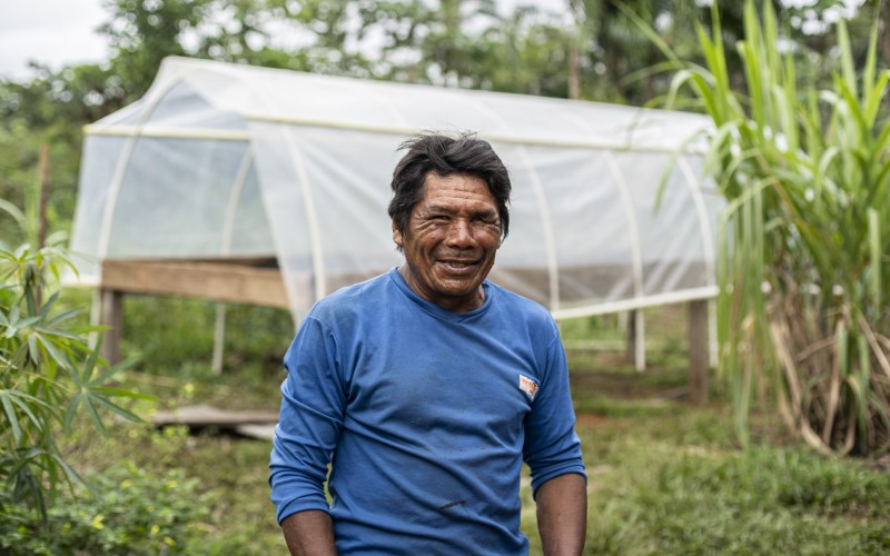 A cacay nut farmer in front of a nut collection point.