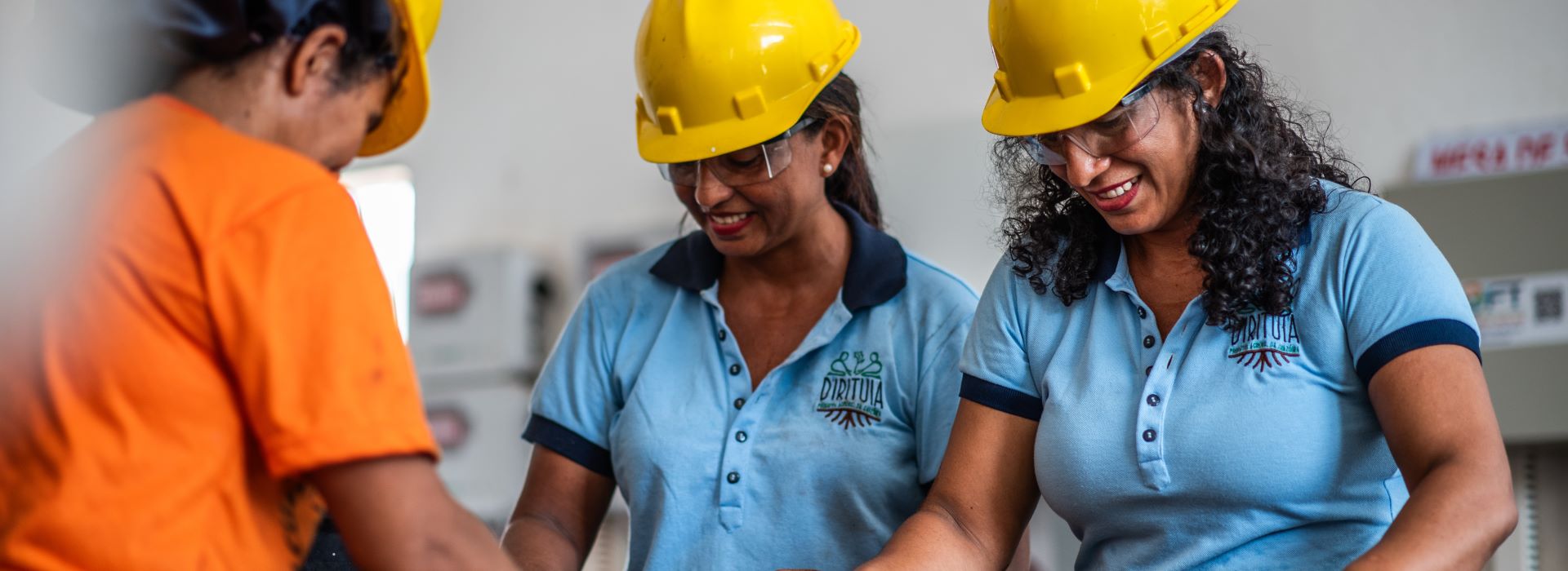 Two women in hard hats selecting seeds.