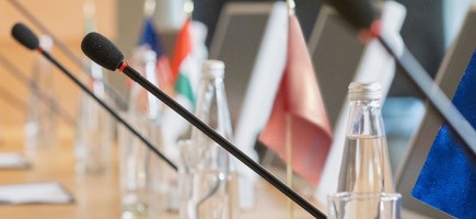 Microphones on a table with different national flags