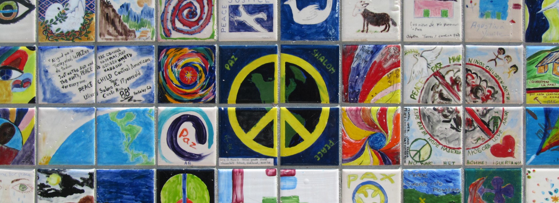 Paintings on peace are displayed on a tiled wall.