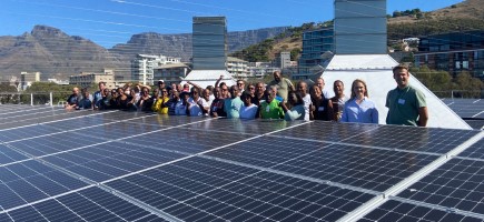 People standing behind rooftop PV panel in Cape Town.